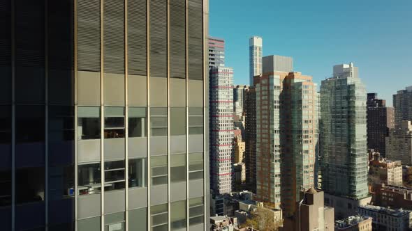 Slide and Pan Footage of High Rise Apartment Buildings in Midtown Illuminated By Bright Sun alt