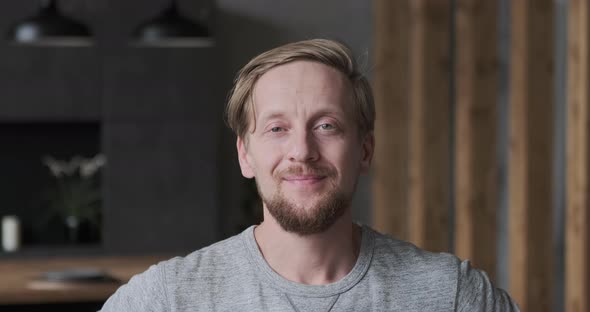 Closeup Portrait of Smiling European Blonde Guy Posing at Luxury Apartment Loft Interior alt