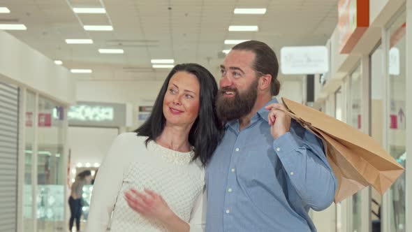 Happy Mature Couple Enjoying Seasonal Sale at Local Shopping Mall alt