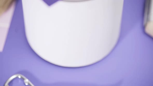 Close up of metal paint can with purple paint and paint swatch. alt