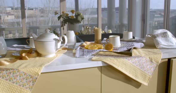 A Long Kitchen Table with a White Marble Top Stands in a Kitchen Filled with Soft Daylight alt