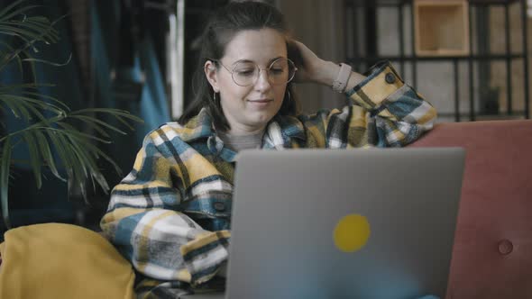 Woman Wearing Round Glasses Works With Laptop At Home alt