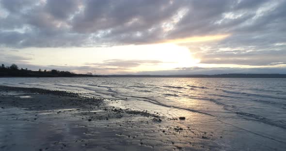 Ocean Beach Washington State Coast Golden Cloudy Skies Flying Above Water Waves Aerial alt