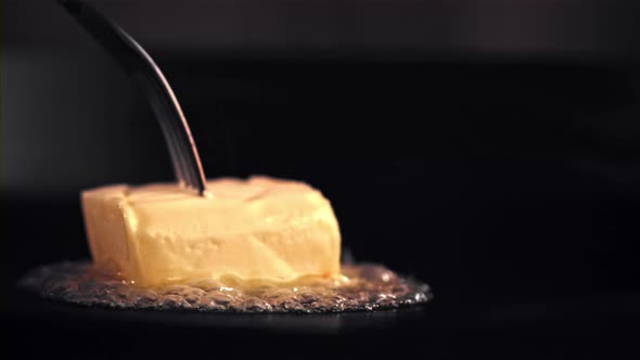 Super Slow Motion a Piece of Butter Melts in a Frying Pan with Air Bubbles alt