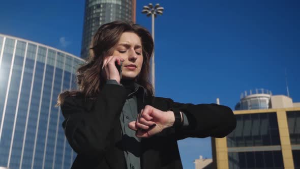 Young Businesswoman Talking on a Phone in the Background of the Urban Landscape alt