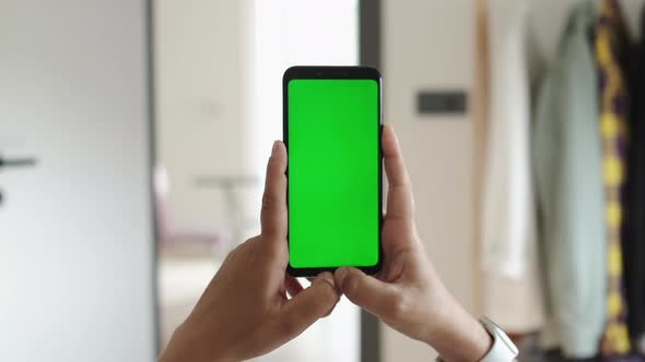 Handheld Slow Motion Camera Point of View of Female at Cozy Room Using Phone With Green Mockup alt