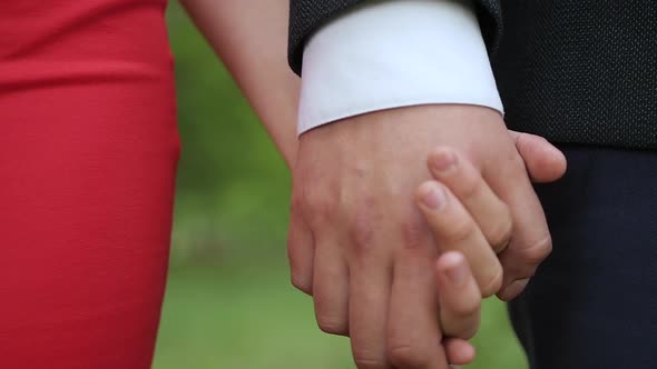 Front View of Couple in Love Holding Hands. Close up of Young Couple's Hands. Romantic Love Concept alt