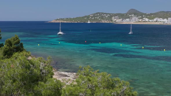 Bay of Ibiza Coastline with Turquoise Water and Yachts on Sunny Summer Day