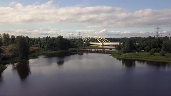 Flying Over Beautiful Landscape a Large Automobile Bridge Over the Lake, Forest. alt