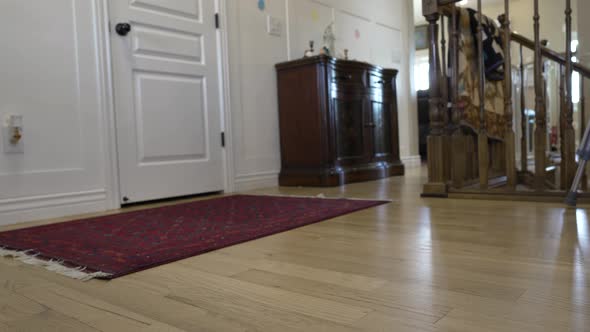 Man with an ankle injury wearing an orthopedic boot and using crutches to get around home alt