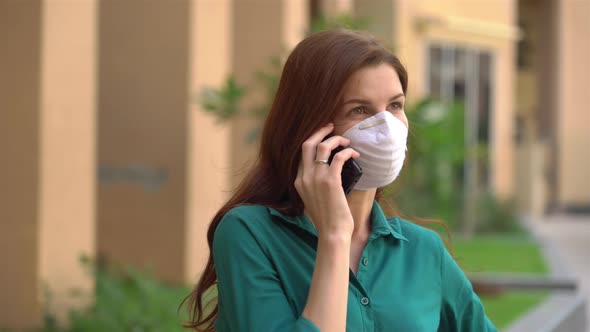  Girl in a Medical Mask Talking on the Phone