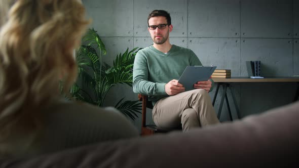 Young psychotherapist with a patient in the office alt