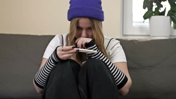 Teenage Girl Looks at the Result of a Pregnancy Test and Cries alt