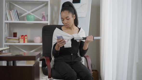 Portrait of Absorbed Engrossed African American Woman Surfing Internet on Smartphone Lifting alt