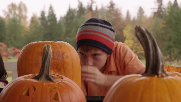 Young boy carving pumpkin for Halloween