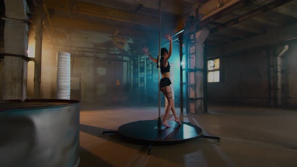 A Girl With Long Legs In A Black Suit And Makeup Rotates At The Pylon alt