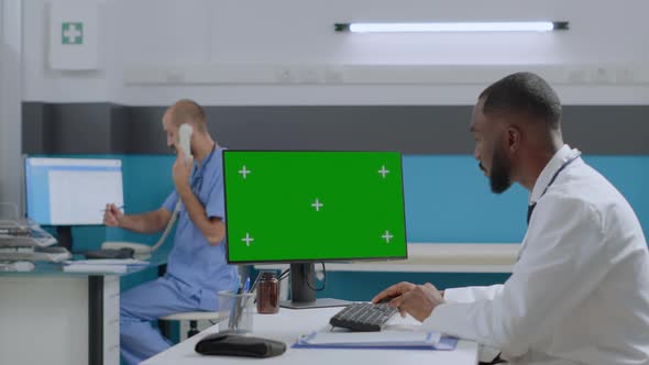 African American Doctor Sitting at Desk in Hospital Office Working at Healthcare Treatment alt