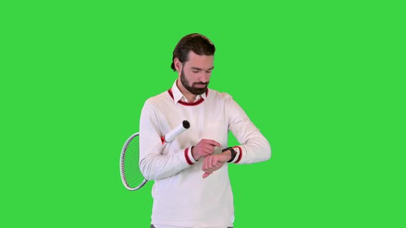 Handsome Male Tennis Player Walking and Using Smart Watch on a Green Screen Chroma Key