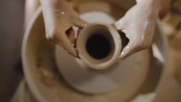 Women's Hands Form Neck of an Earthenware Jug From White Clay on Potter's Wheel