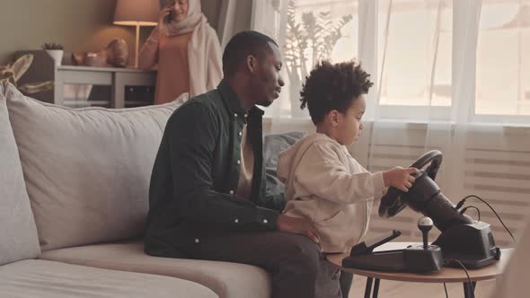 African American Father and Little Son Playing Race Video Game alt