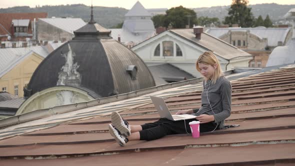 Woman with laptop and a coffee cup on the roof alt