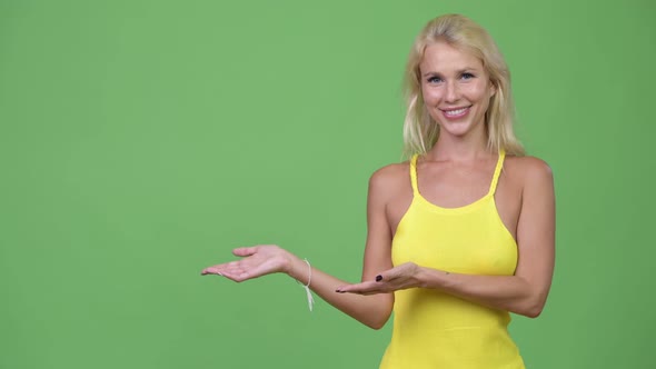 Young Happy Beautiful Blonde Woman Showing Something