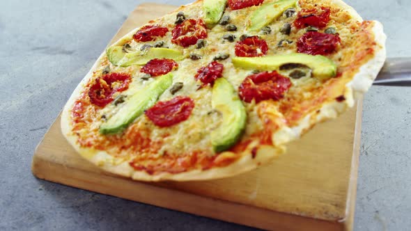 Baked pizza served on wooden board alt