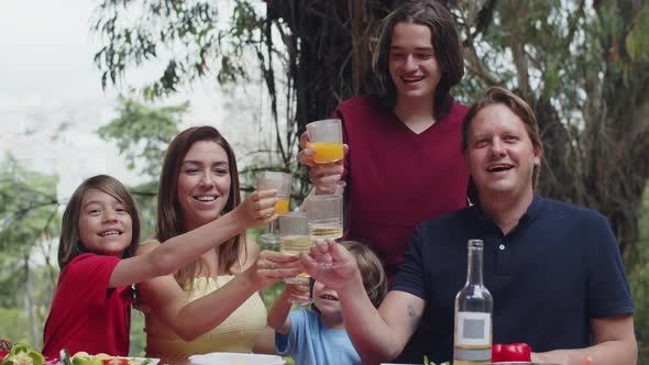 Big Caucasian Family Sitting at Table and Clinking Glasses alt