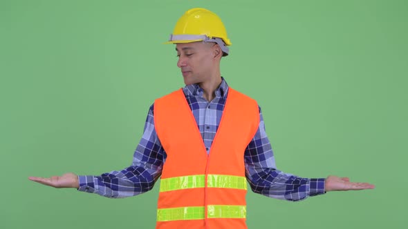 Happy Multi Ethnic Man Construction Worker Comparing Something alt