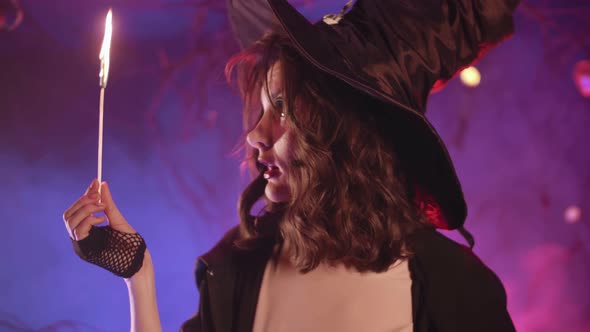 A witch puts out a match while setting fire to a pumpkin for halloween.  Halloween!  4K.Stock vide