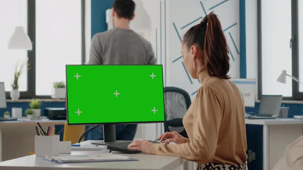 Woman Working with Isolated Green Screen on Monitor at Desk alt