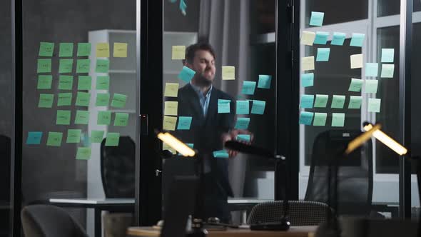 Angry Man Rips and Throws Paper Stickers and Notes From a Glass Board in the Office a Man Takes Out alt