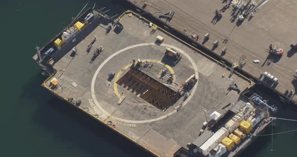 Aerial helicopter shot, track man as he exits brown 1970s car and jogs towards snowy bridge over Ala alt