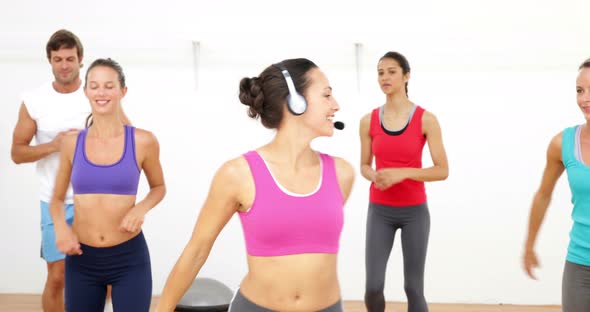 Aerobics Class Stepping Together Led By Instructor alt
