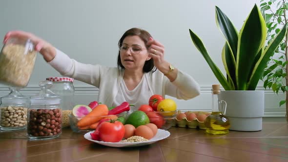 Woman Nutritionist Showing Healthy Food Plate with Vegetables Fruits Grains Nuts alt