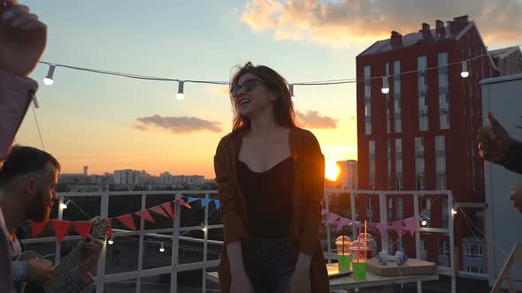 Friends having fun at the rooftop party, dancing 