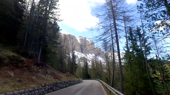 View from a driving car on the winding roads in the mountains, Dolomites, Alps alt