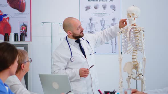 Specialist Doctor Showing Body Bone Functionson Using Skeleton Model alt