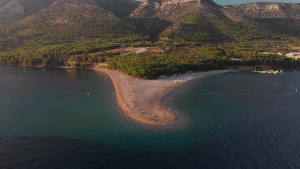 Slowly flying toward the beachhead of Zlatni Rat on the island of Brac in Croatia, tilting down as t alt
