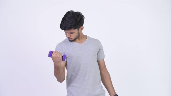 Young Handsome Bearded Indian Man Exercising with Dumbbells alt