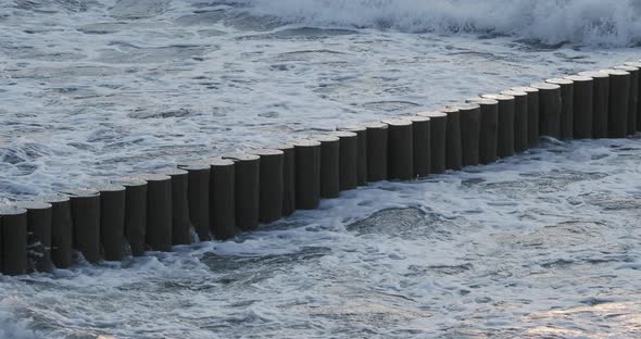 Breakwater of Larch Logs. Strengthening the Seashore To Keep the Sand on the Beach. Gorgeous Sunset alt