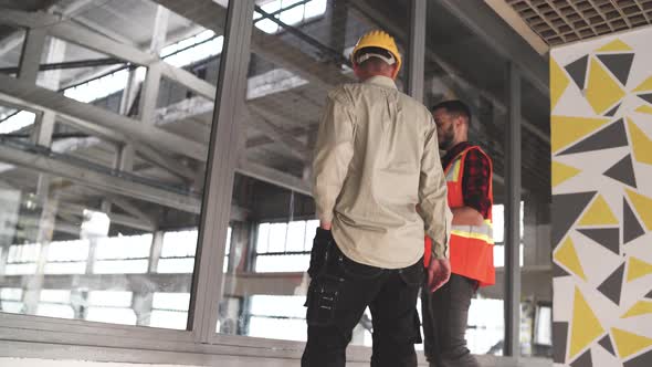 Construction Engineer Discussion with Architect at Construction Site or Building Site alt