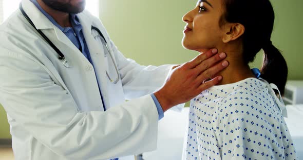 Doctor examining patients neck in the hospital alt