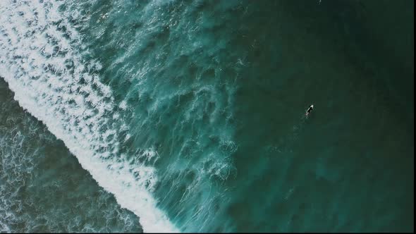 Aerial footage of surfers on the west coast of Portugal. alt