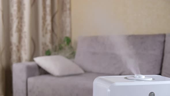 Ultrasonic humidifier in the house. Steam from white air moistener distributing fume in the room