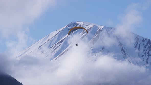 Parachute sky-diver flies in mountains alt