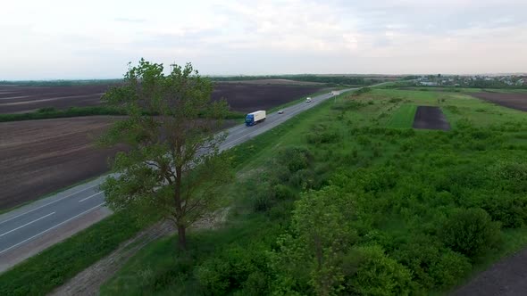 Aerial Shot of Truck Driving a Road Benween Fields