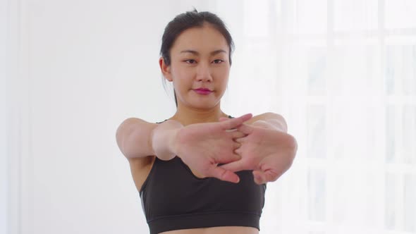 Calm of Asian woman in sportwear stretching muslce to warm up breathing and meditation with yoga at alt
