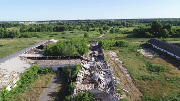 Flying Over an Abandoned and Destroyed Farm. Ruined Cowsheds and Farmyard. alt