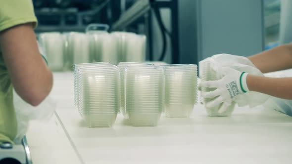 Factory Workers Are Packing Plastic Containers Into Polyethylene alt